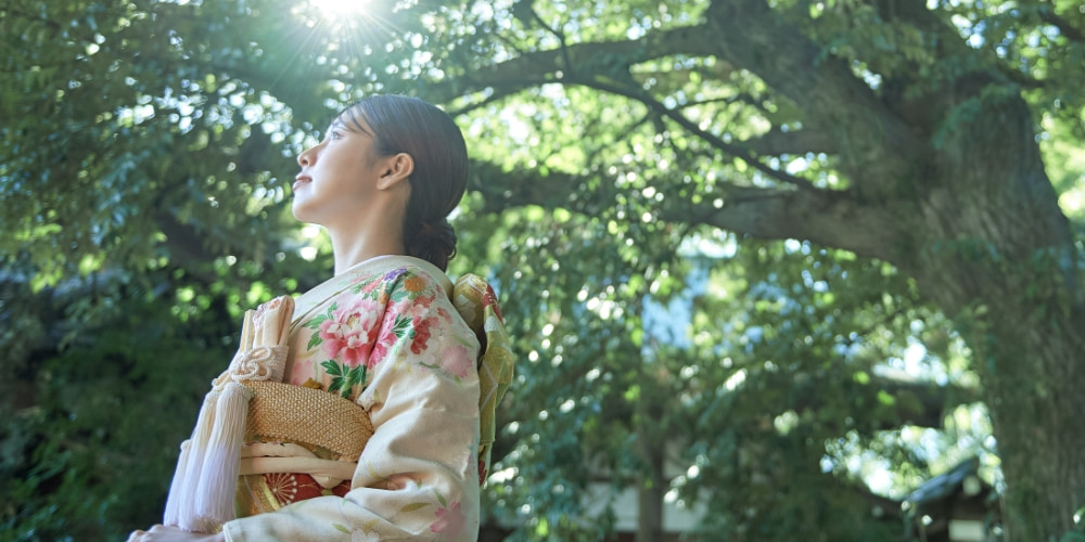春日神社の境内で見上げる新婦の写真