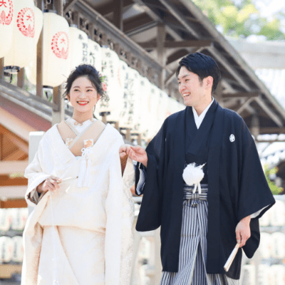 春日神社の境内で新郎新婦が手を取り合う写真